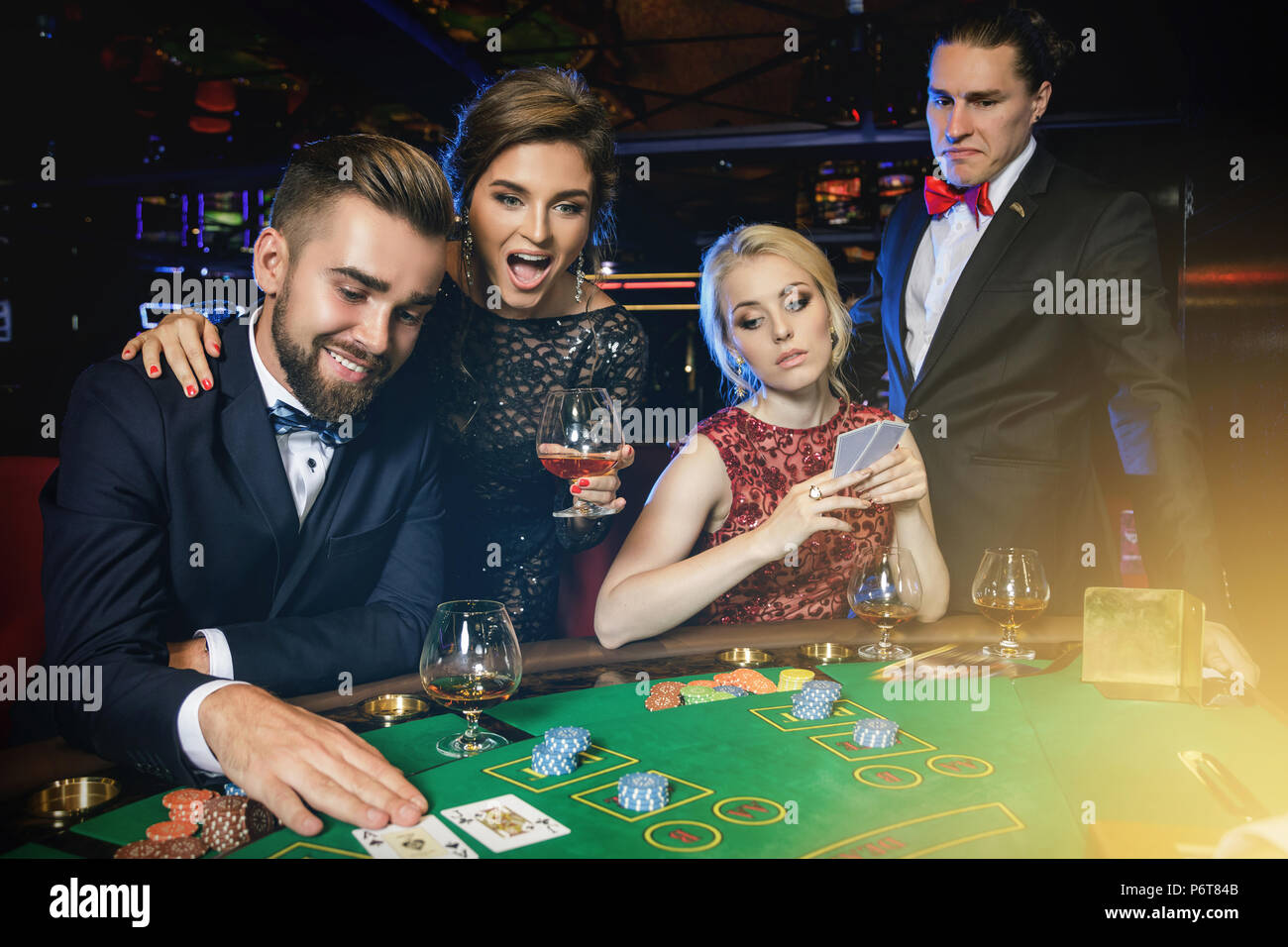 Vinti e vincitori. Gruppo di ricchi ben vestito la gente sta giocando a poker al casinò. Concetti di vita di lusso Foto Stock