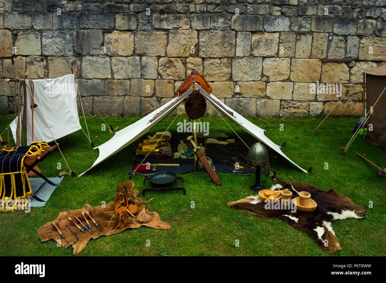 Ricreazione di una tenda in un accampamento romano pieno di armi, vestiti e materiali del tempo. La vita nella Roma antica. Foto Stock