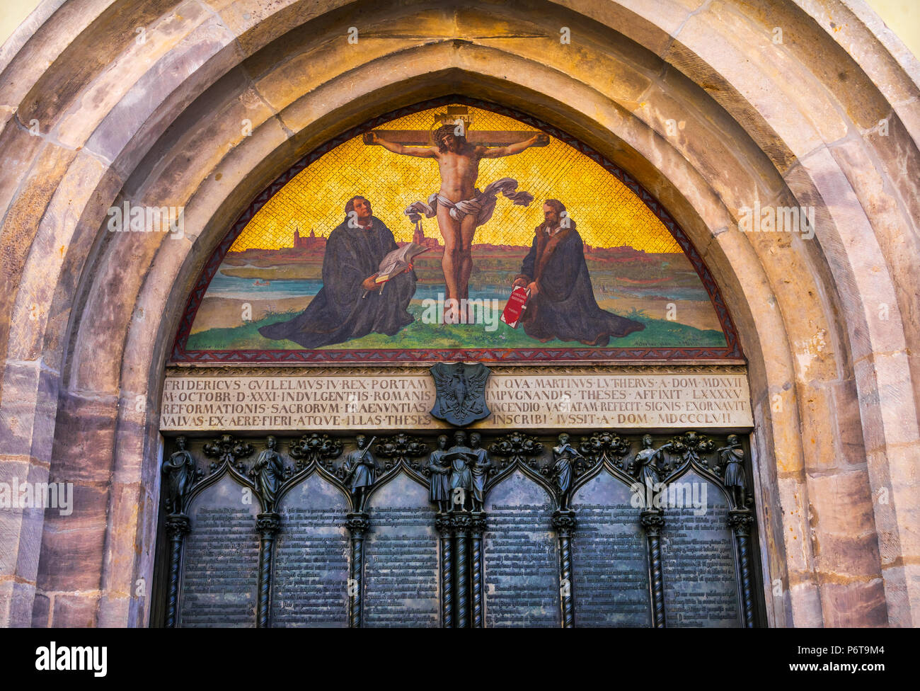 95 Tesi Lutero porta la crocifissione di Gesù il castello di mosaico Chiesa Schlosskirche Lutherstadt Wittenberg in Germania. Porta dove Lutero pubblicato 95 tesi di laurea 1517 st Foto Stock