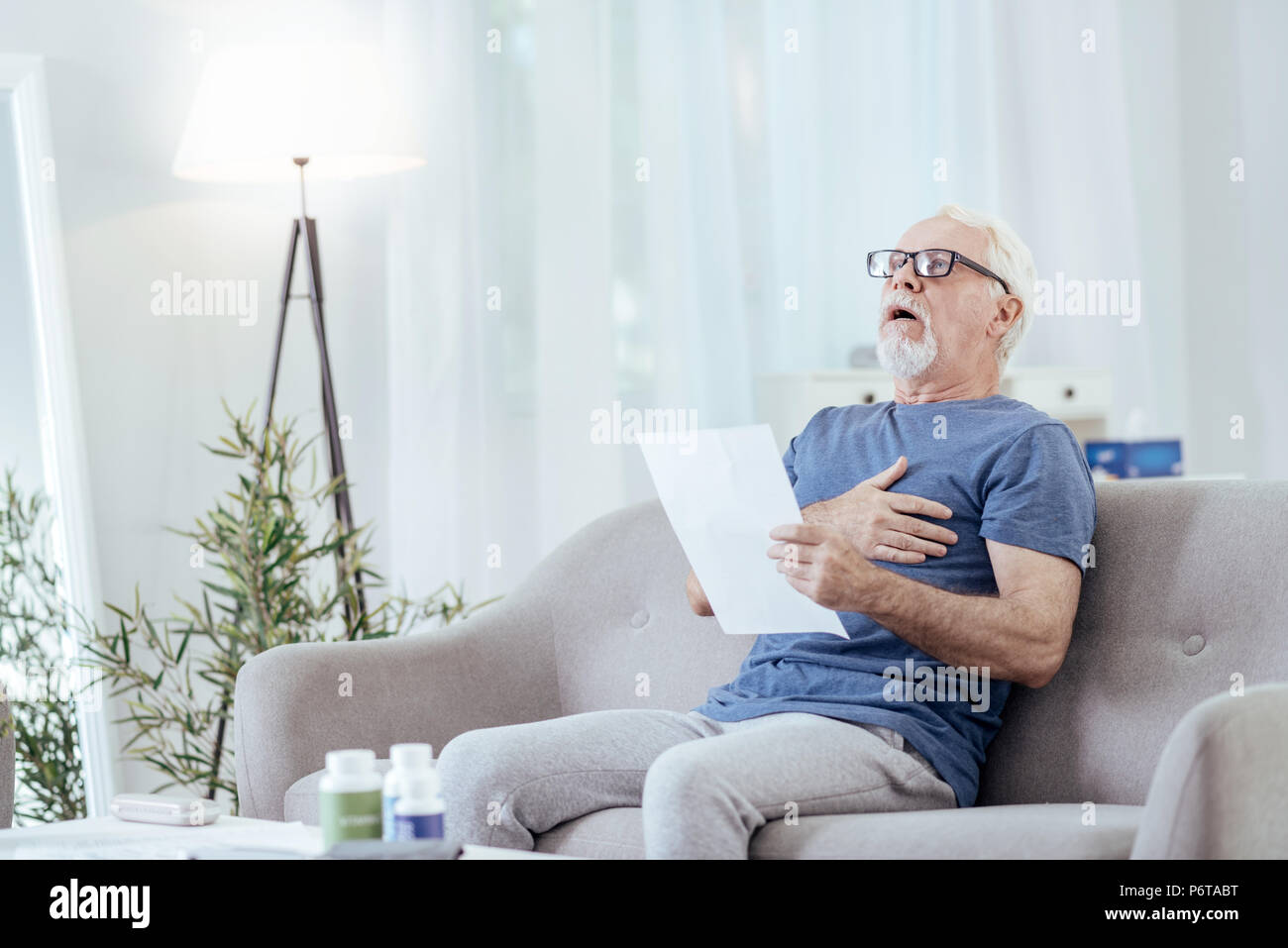 Stupito senior Man aventi i bruciori di stomaco Foto Stock