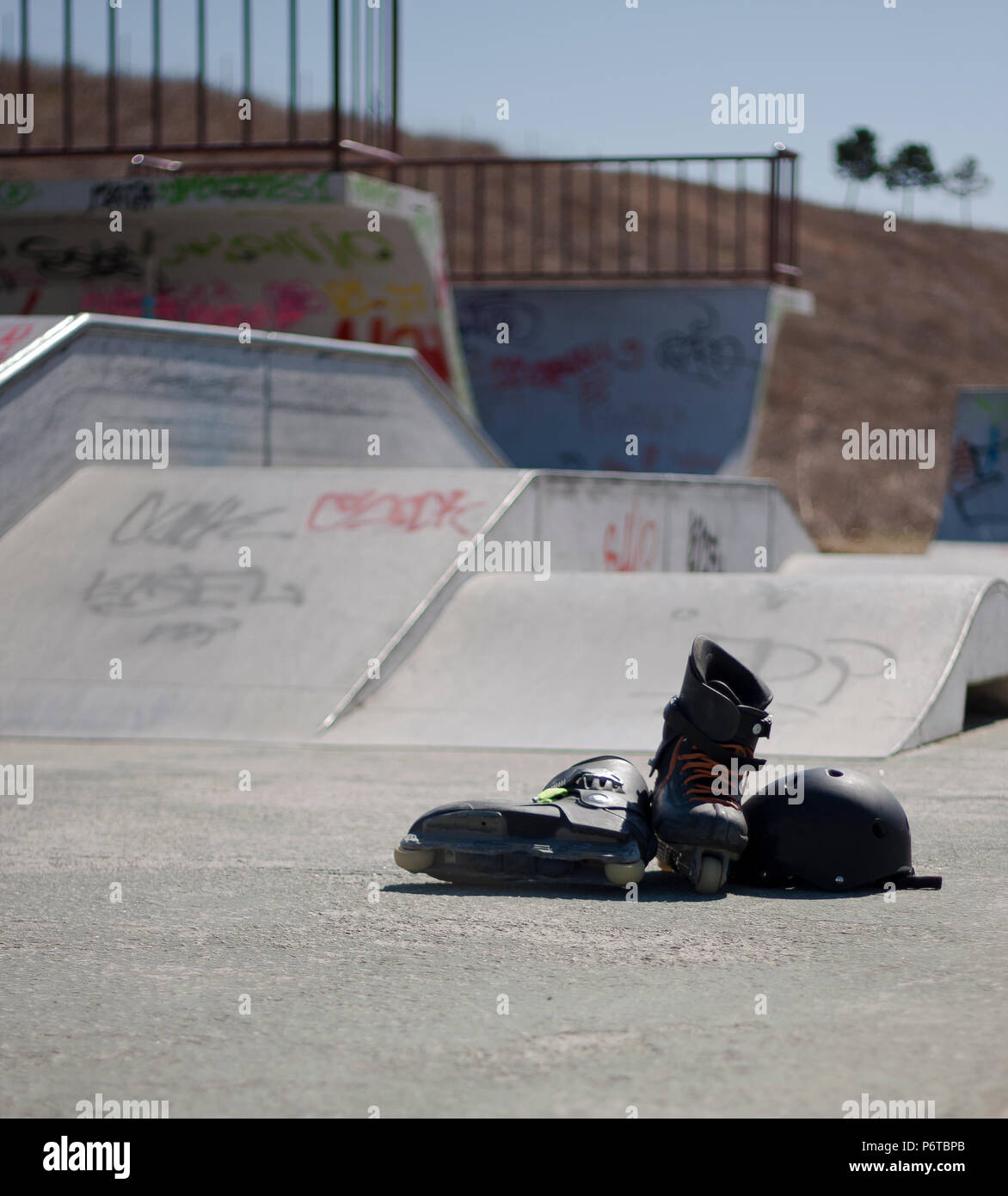 Pattino a rotelle in linea casco di protezione in un cemento skatepark Foto Stock