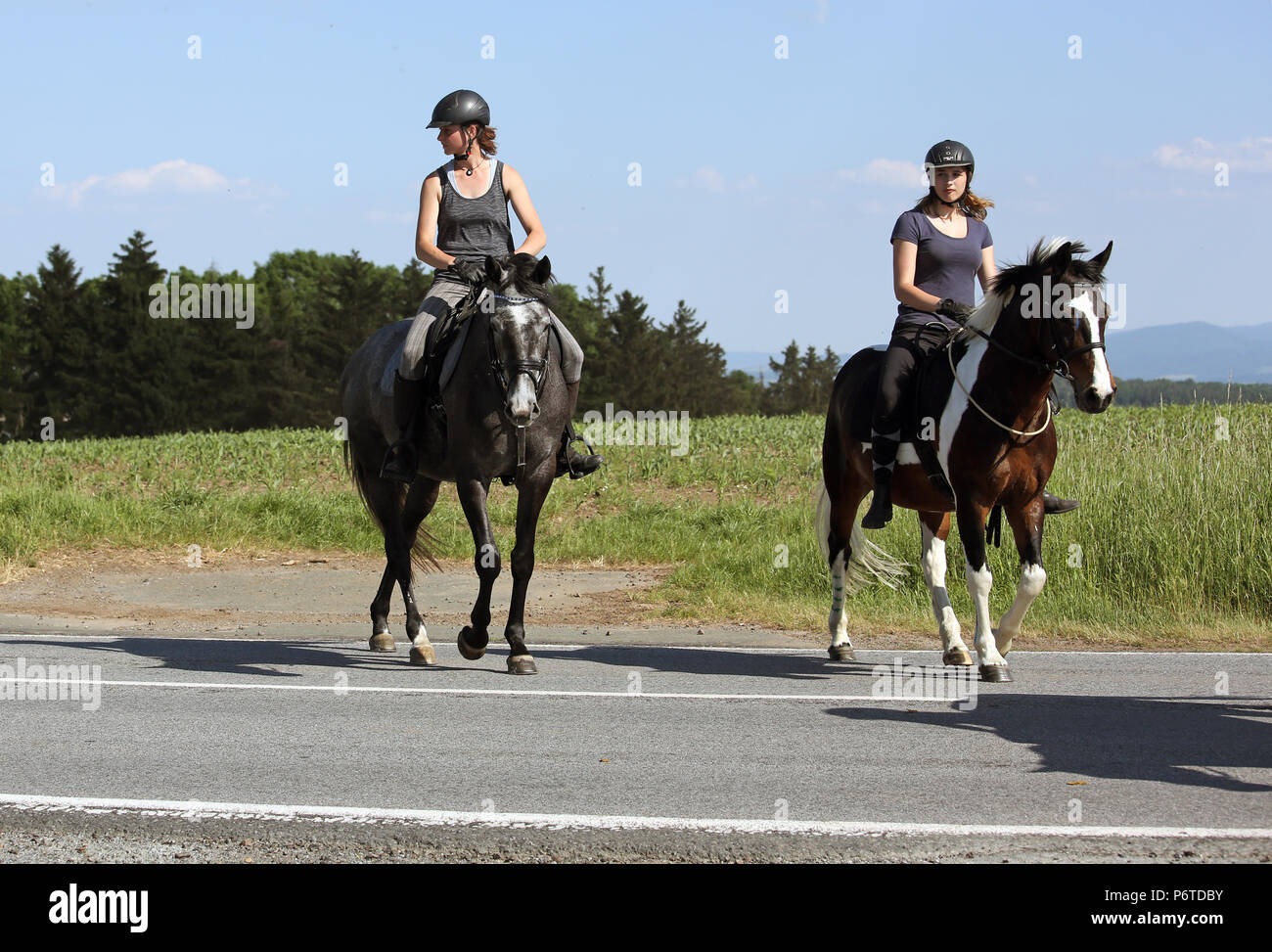 Oberoderwitz, giovani donne attraversando una strada di campagna su un giro Foto Stock