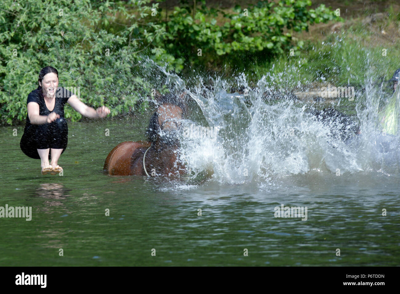 Oberoderwitz, donna jumping dal suo cavallo in un lago Foto Stock