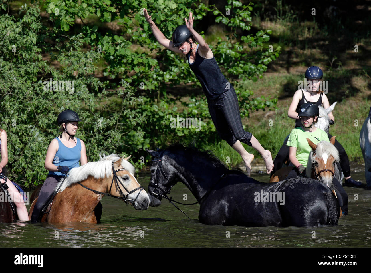 Oberoderwitz, donna jumping dal suo cavallo in un lago Foto Stock