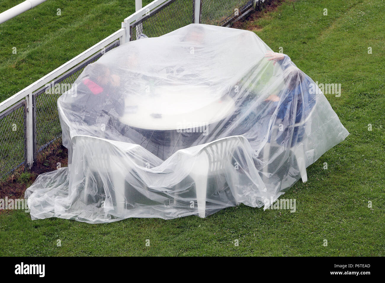 Amburgo, spettatori seduti sotto la pioggia sotto un telone in materiale plastico in corrispondenza di una tabella di corsa Foto Stock