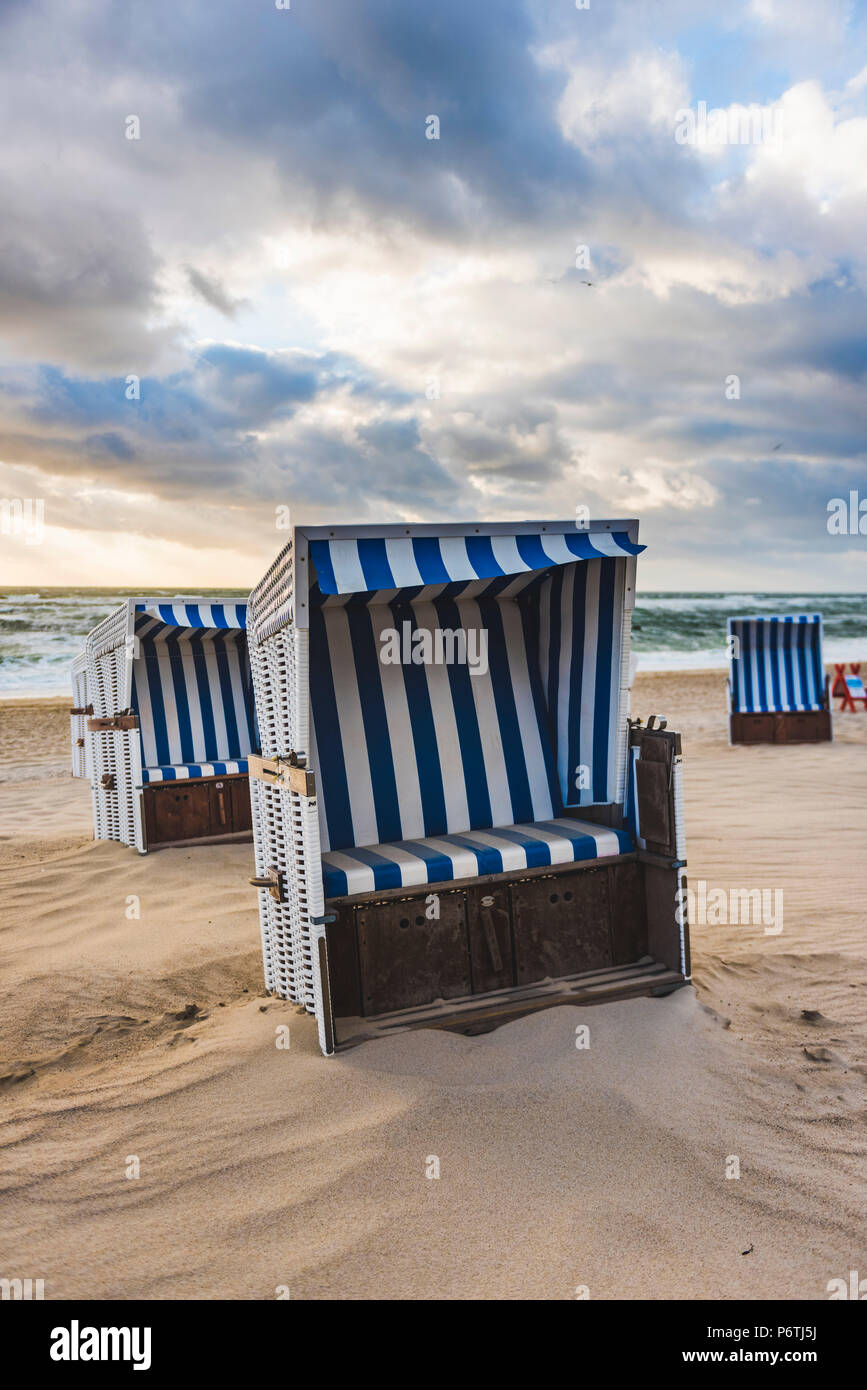 Kampen, isola di Sylt, Frisia settentrionale, Schleswig-Holstein, Germania. Strandkorbs sulla spiaggia al tramonto. Foto Stock