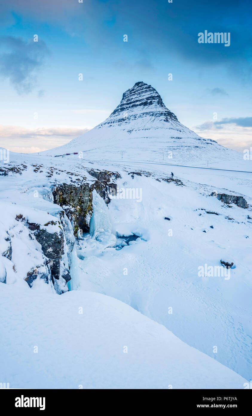 Penisola Snaefellsness, Western Islanda, l'Europa. Congelati Kirkjufellfoss cascata in inverno con Kirkjufell in montagna lo sfondo. Foto Stock