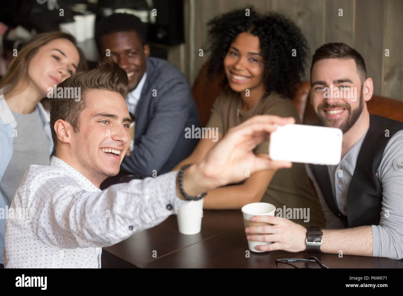 Diversi colleghi sorridere per foto di gruppo in appoggio al cafe Foto Stock