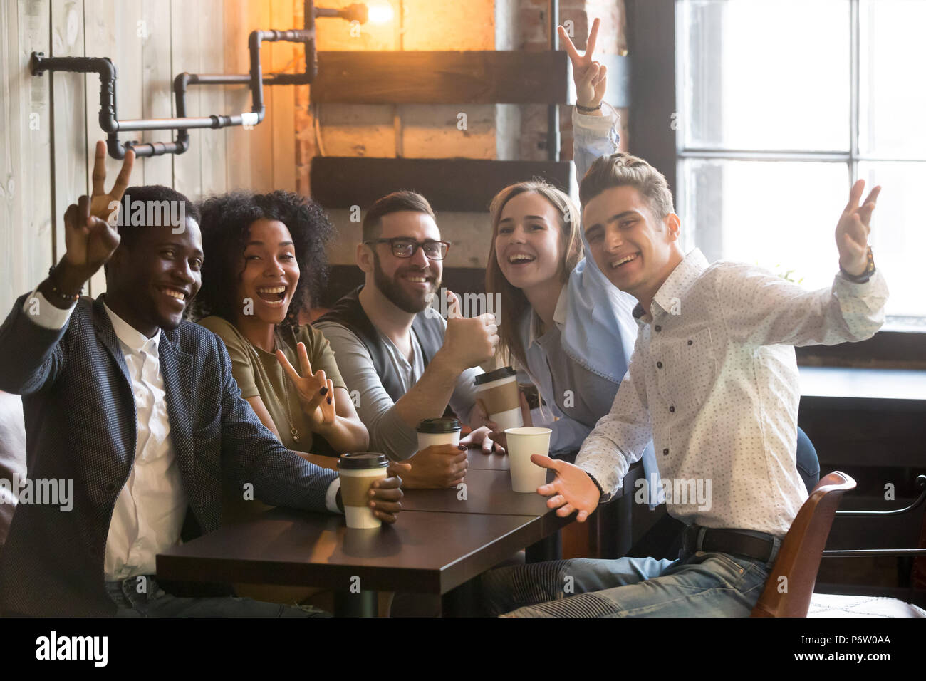 Sorridente diversi colleghi millenaria che posano per una foto in cafe Foto Stock