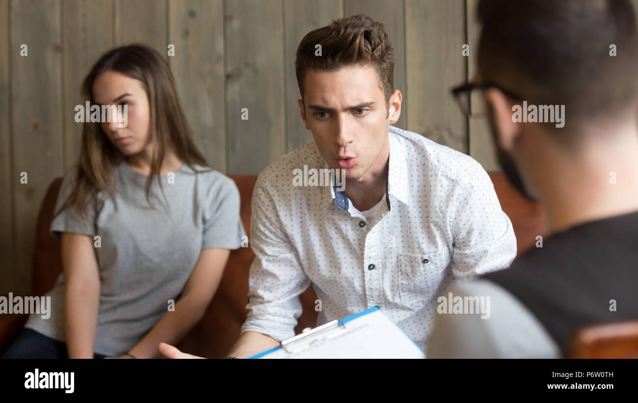 Mad Caucasian marito parlando di problemi familiari con psychol Foto Stock