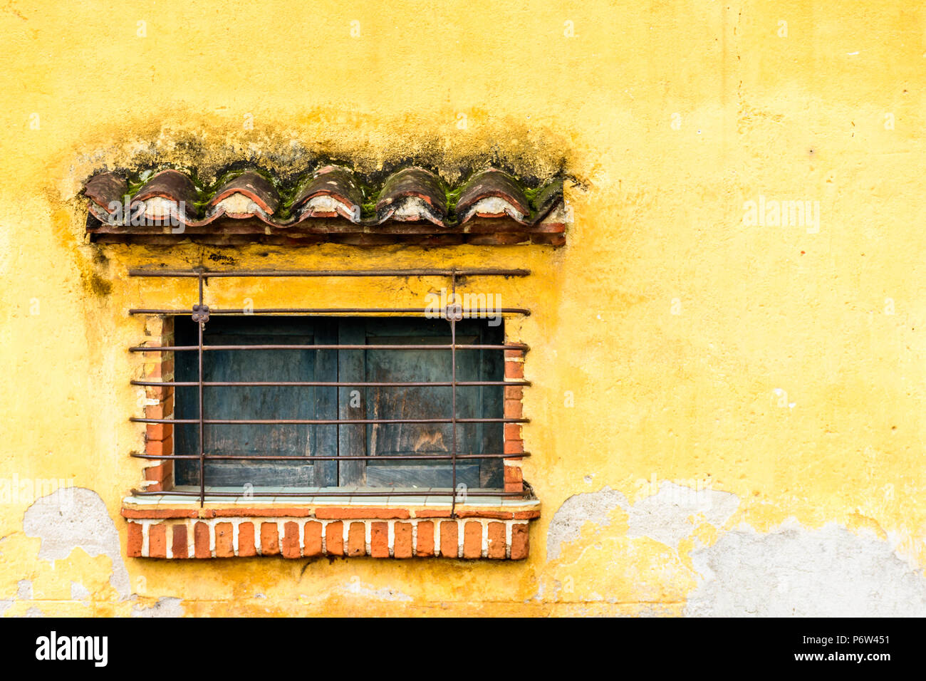 Bloccate e la finestra ritagliata nel muro di giallo, America Centrale Foto Stock