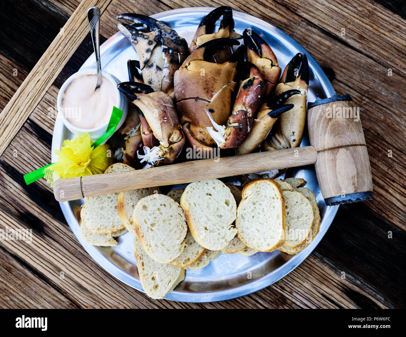 Piastra con gambe sode e chele di granchio marrone con pane e dip sul tavolo di legno Foto Stock