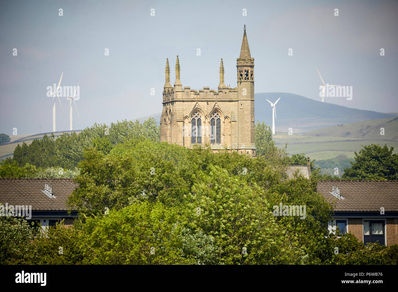 Rochdale ridondante Saint Edmund la Chiesa un tempio alla massoneria con fattorie del vento sulle colline dietro Foto Stock