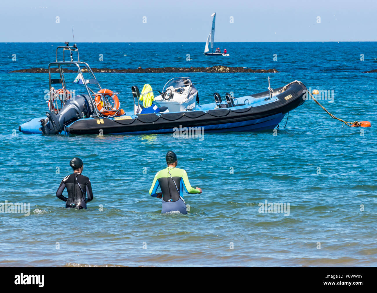 West Bay Beach, North Berwick, East Lothian, Scozia, Regno Unito, 3 luglio 2018. L'ondata di caldo in Scozia continua. Un paio in neoprene nuotare nel mare Foto Stock