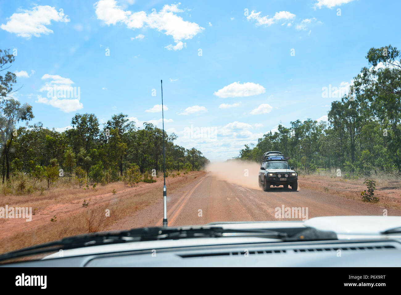 La polvere rossa volare dietro un auto in arrivo sulla penisola di strada di sviluppo (PDR), Cape York Peninsula, estremo Nord Queensland, FNQ, QLD, Australia Foto Stock