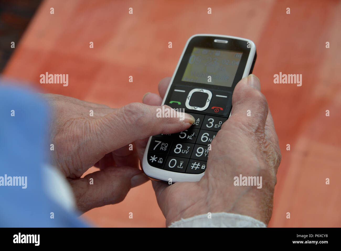 Telefono cellulare nella vecchia donna con le mani in mano Foto Stock