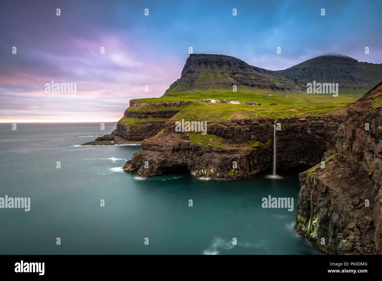 Gasadalur, funzionario ministeriale isola, isole Faerøer, Danimarca. La cascata iconica saltando dalla scogliera nell'oceano. Foto Stock