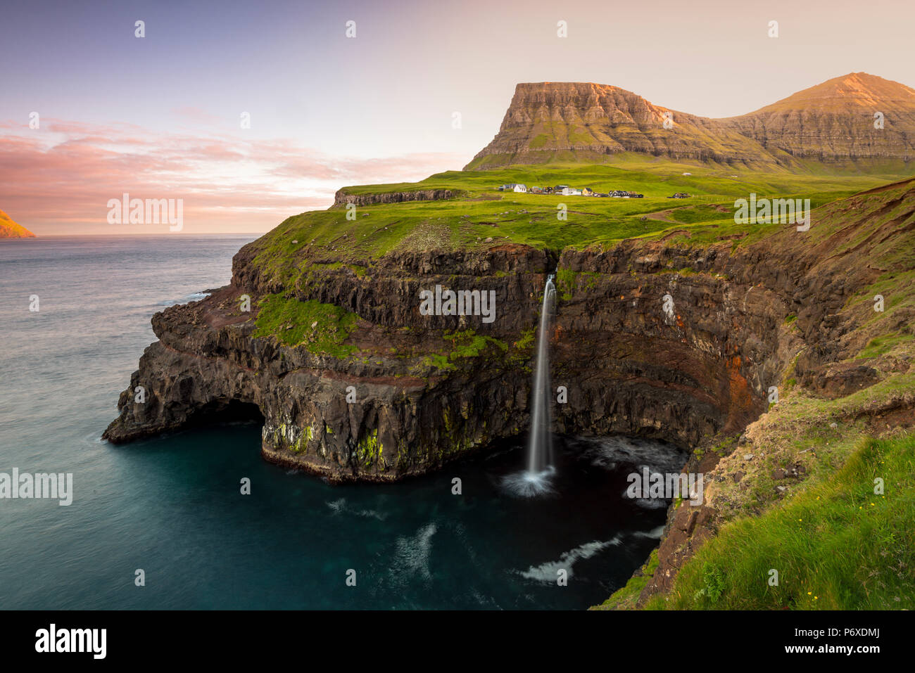 Gasadalur, funzionario ministeriale isola, isole Faerøer, Danimarca. La cascata iconica saltando dalla scogliera nell'oceano. Foto Stock