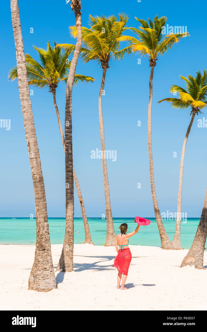 Spiaggia Juanillo (playa Juanillo), Punta Cana, Repubblica Dominicana. Donna relax su una spiaggia orlata di palme (MR). Foto Stock