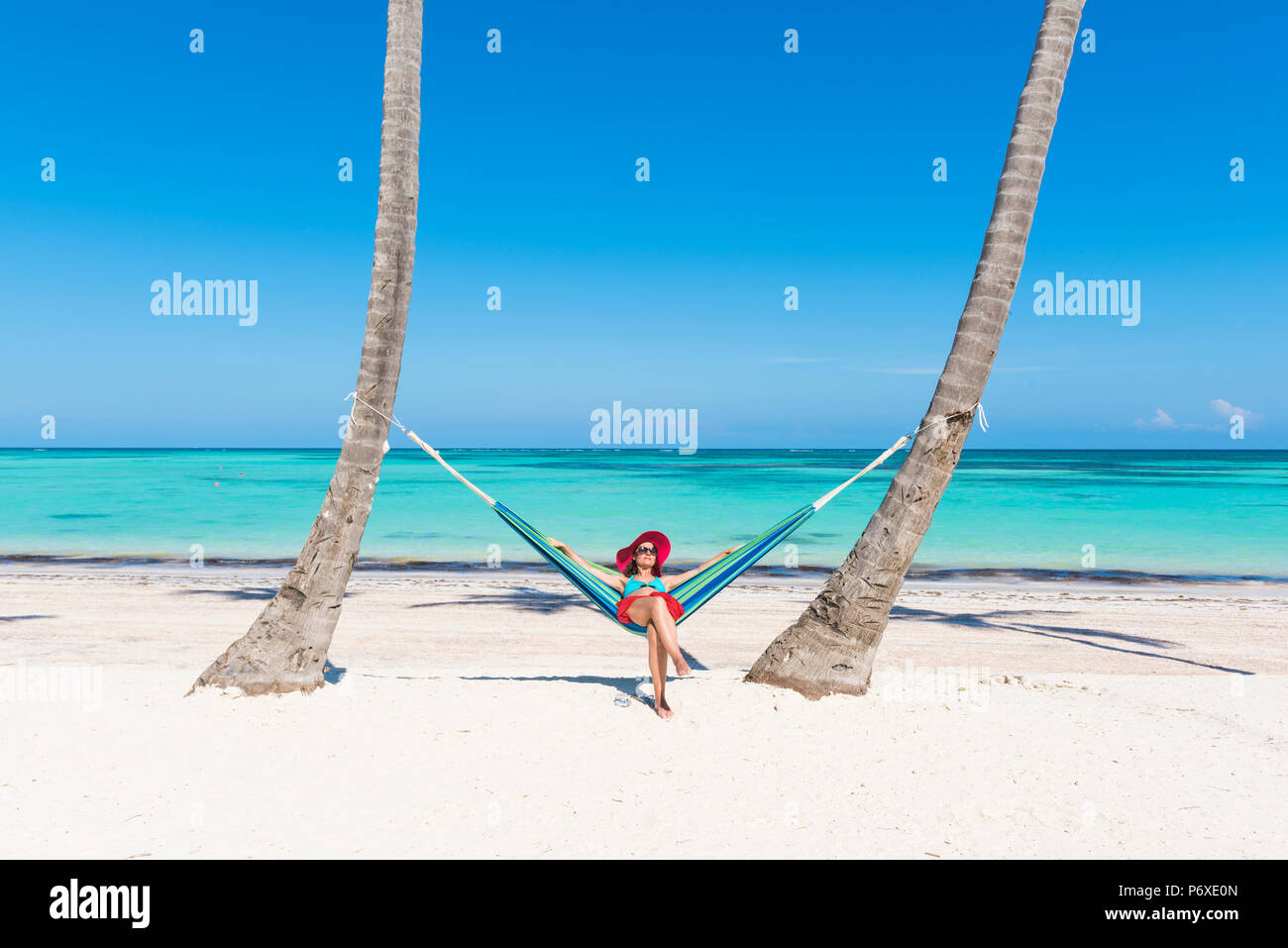 Spiaggia Juanillo (playa Juanillo), Punta Cana, Repubblica Dominicana. Donna relax su una amaca sulla spiaggia (MR). Foto Stock