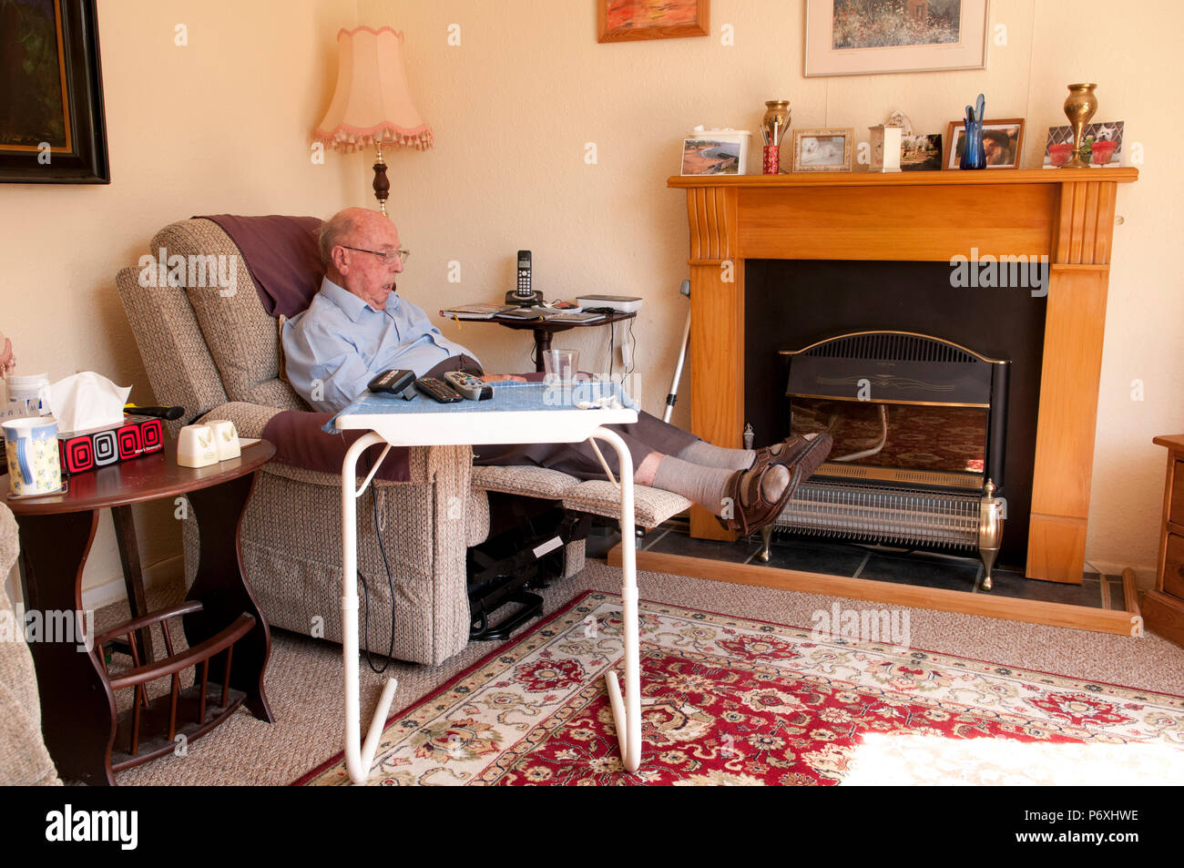 Uomo anziano snoozing in aumento e sedia reclinabile Foto Stock