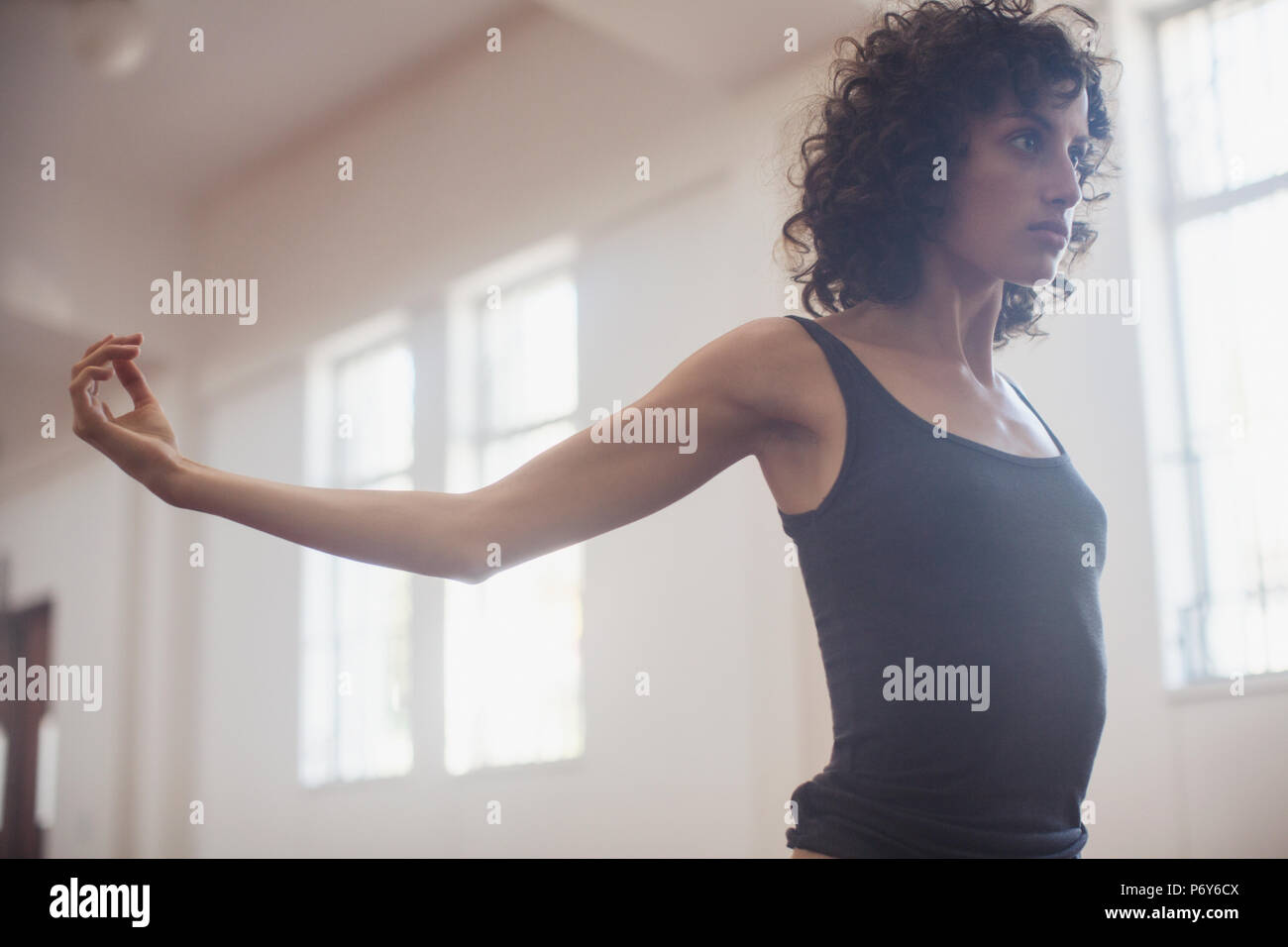 Focalizzata, determinata giovane ballerino femmina stretching in studio di danza Foto Stock