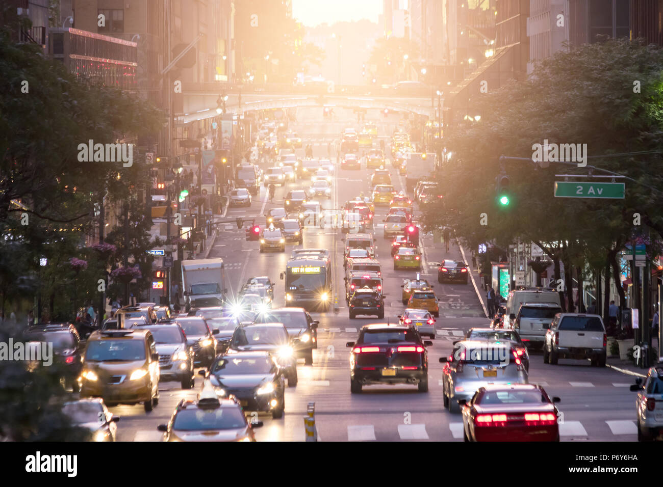 Attraversate il traffico sulla 42nd Street nel centro di Manhattan a New York City con la luce del sole in background Foto Stock