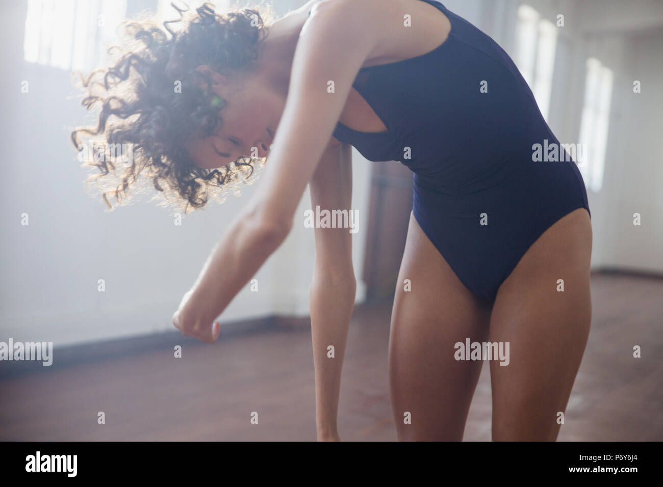Giovane femmina stretching ballerino in studio di danza Foto Stock