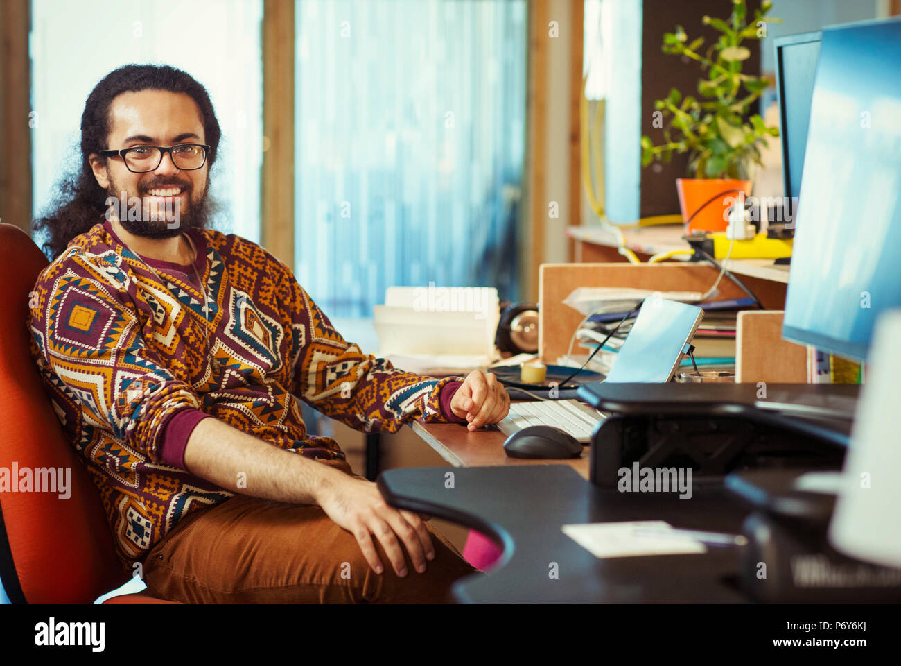 Ritratto sorridente e fiducioso imprenditore creativo lavorare alla scrivania Foto Stock