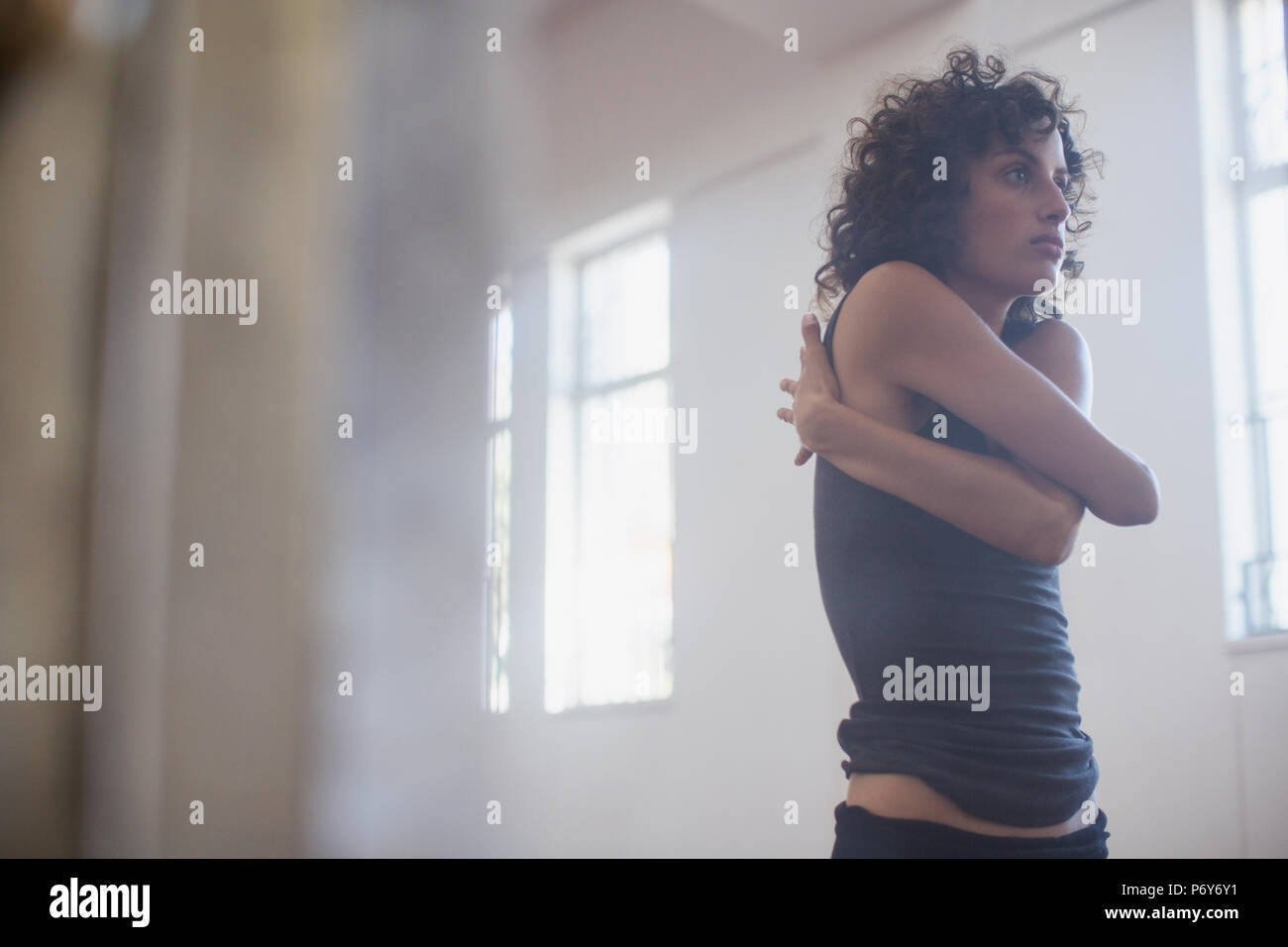 Focalizzata, dedicato giovane ballerino femmina stretching in studio di danza Foto Stock