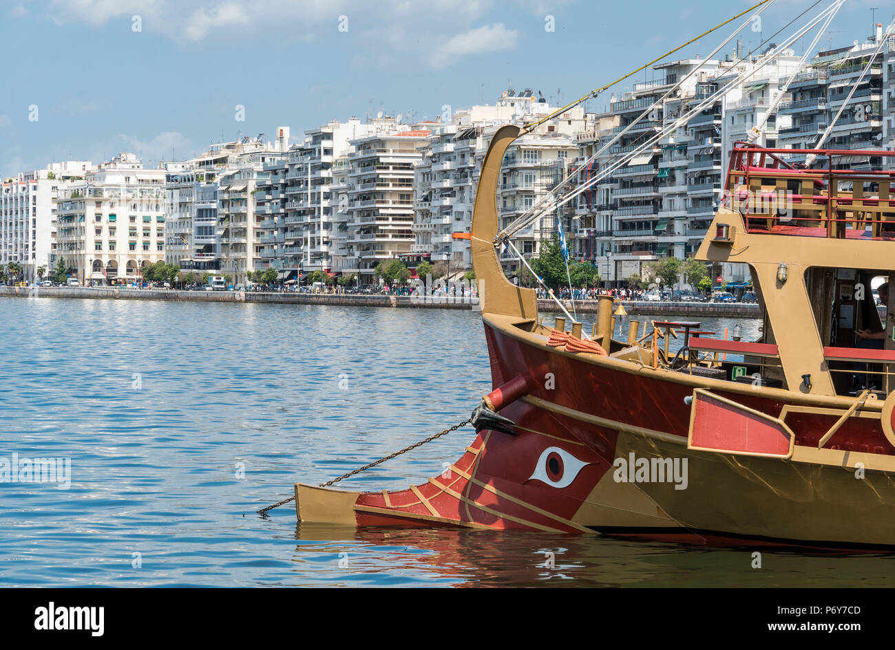 La prua di una crociera turistica barca sul lungomare di Salonicco con i blocchi di appartamenti in Nikis Avenue in background, Macedonia, Grecia settentrionale Foto Stock