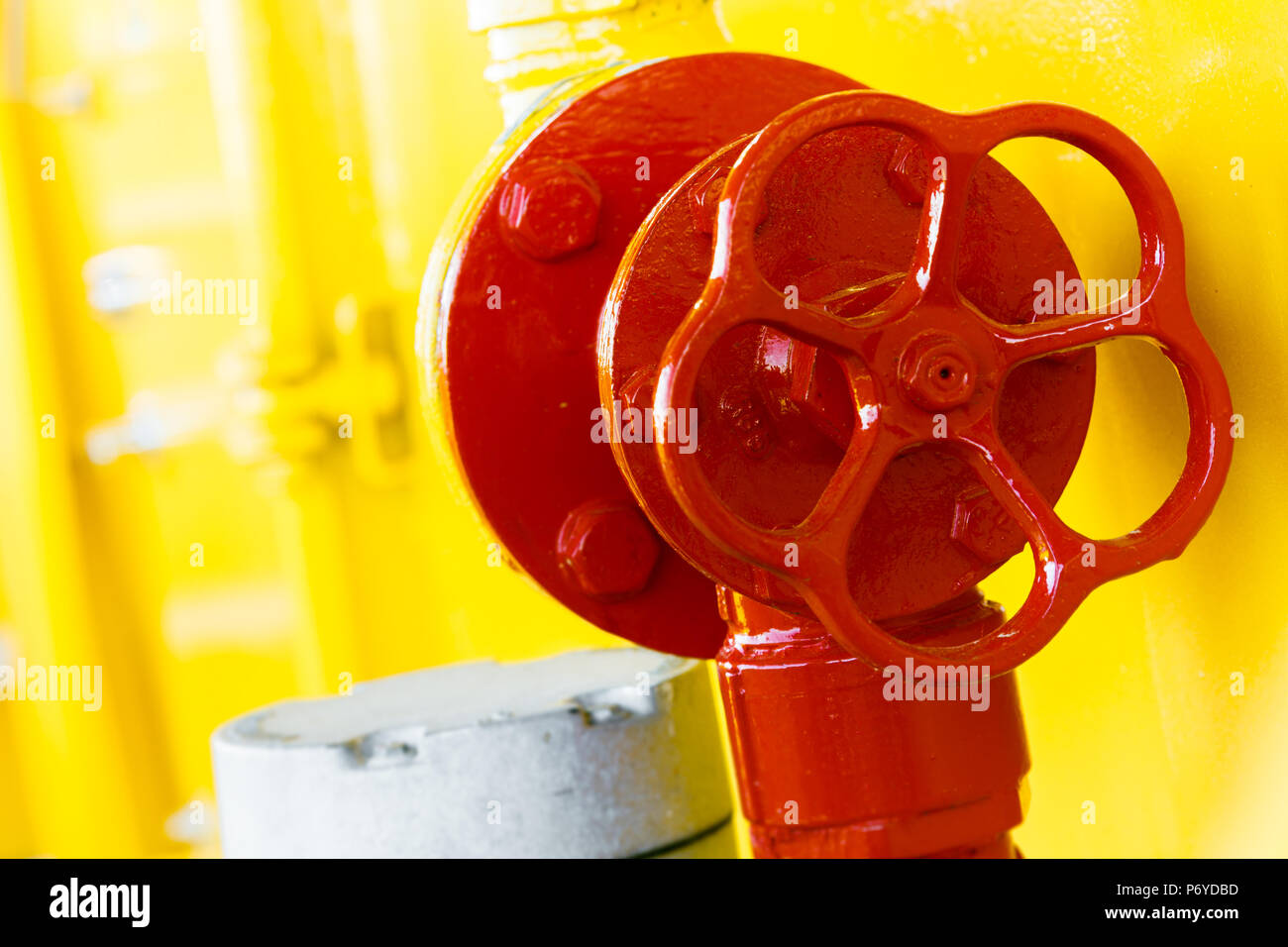 La vibrante maniglia rossa in condizioni di luce solare intensa su sfondo giallo Foto Stock