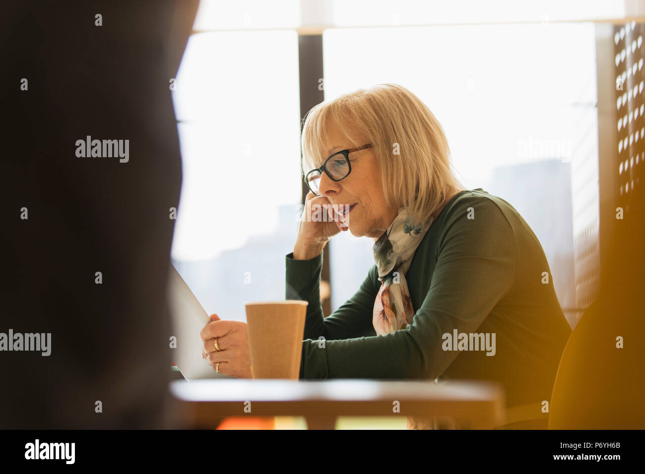 Focalizzato senior imprenditrice utilizzando tavoletta digitale Foto Stock