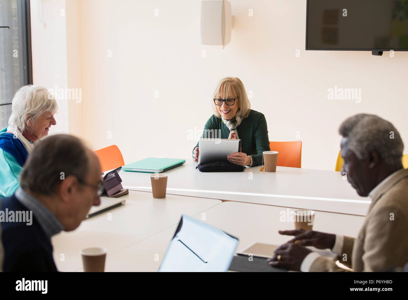 Senior imprenditrice utilizzando digitale compressa, che conduce alla sala conferenze Sale riunioni Foto Stock