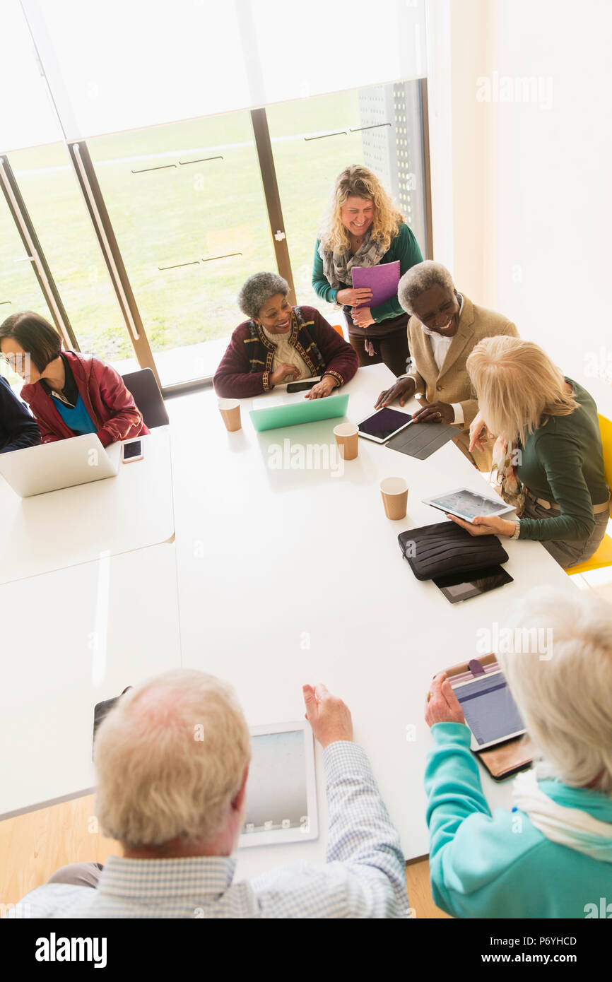 Senior business persone utilizzando le compresse digitali e portatili in sala conferenza incontro Foto Stock