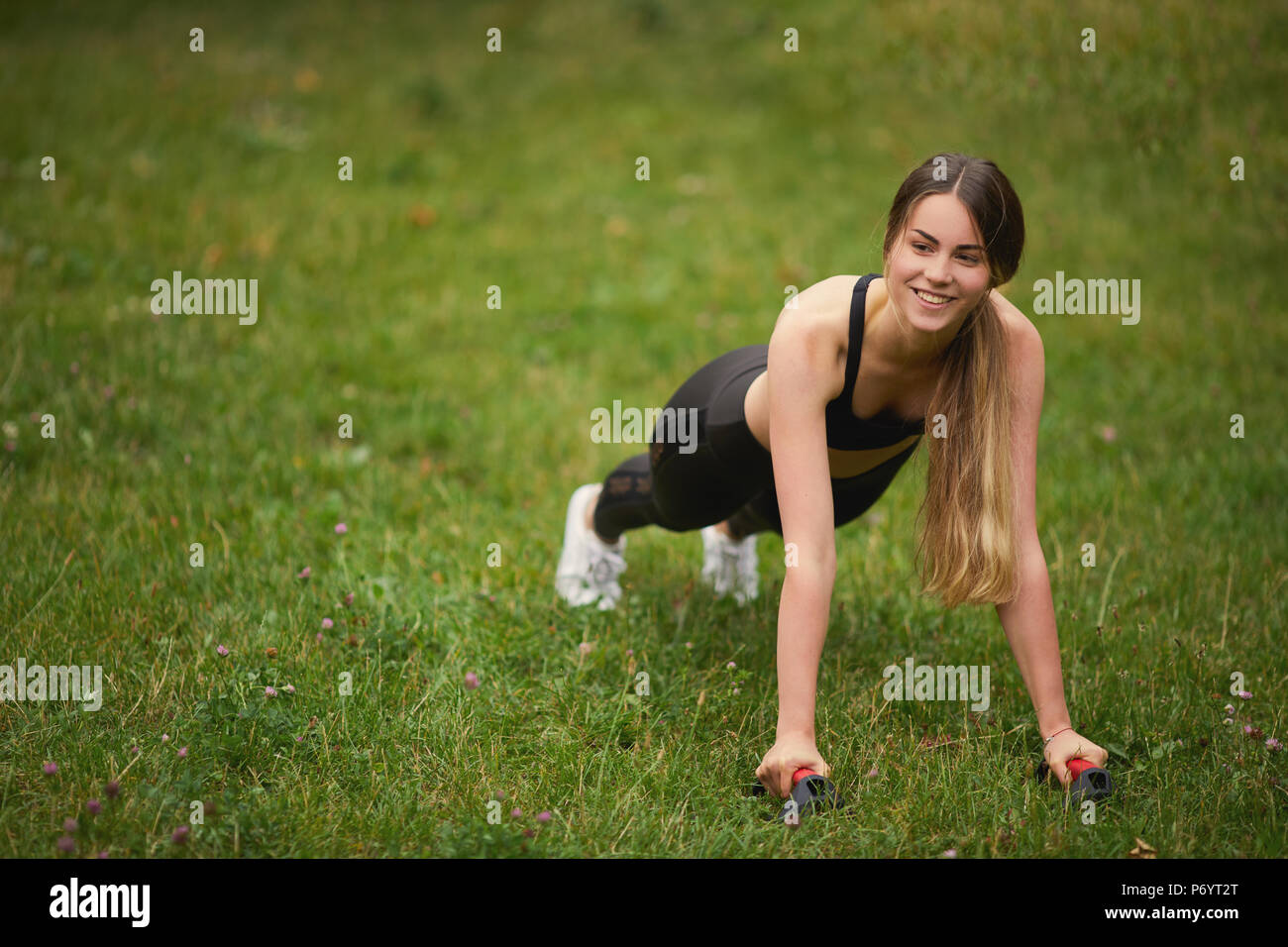 Montare Pretty girl facendo ups push sullo sfondo del parco Foto Stock