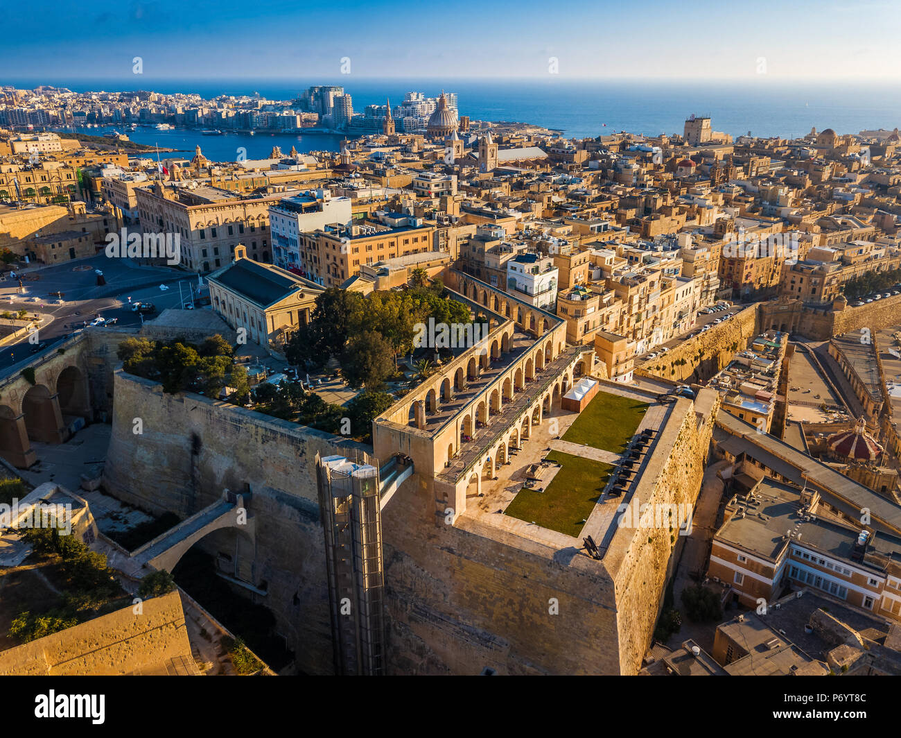 La Valletta, Malta - Antenna vista sullo skyline di La Valletta con batteria a salve e Upper Barrakka Gardens presso sunrise Foto Stock