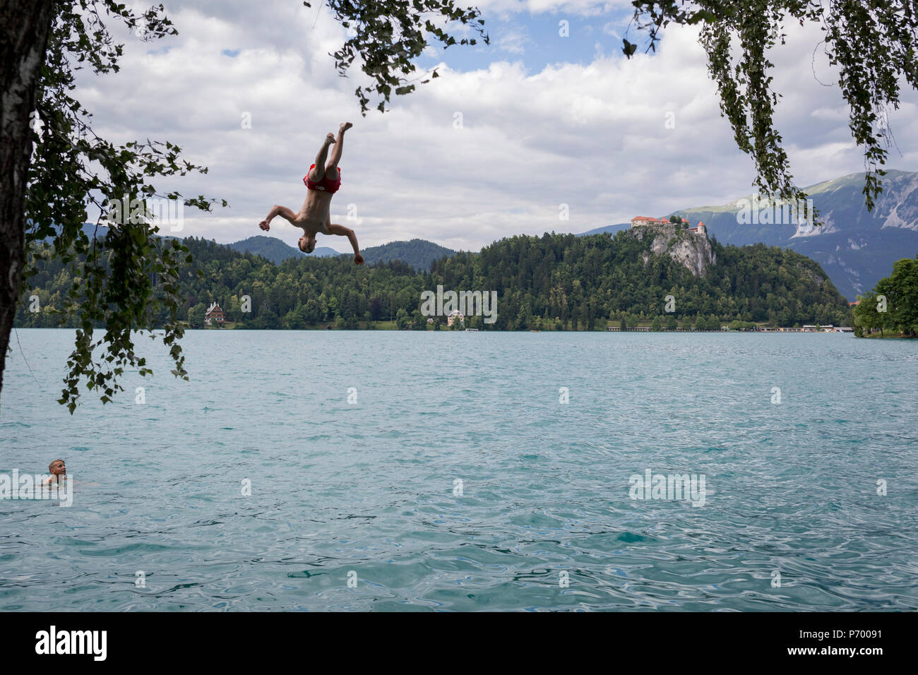 Un ragazzo si tuffa nell'acqua fresca del lago di Bled, il 18 giugno 2018, a Bled, Slovenia. Foto Stock