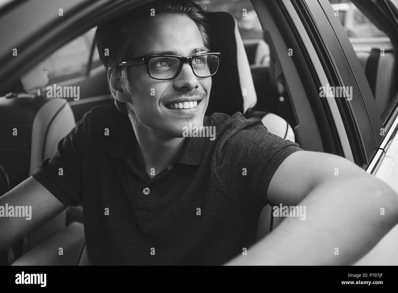 Godetevi l'unità. Immagine del giovane bello ragazzo seduto in auto. Foto Stock