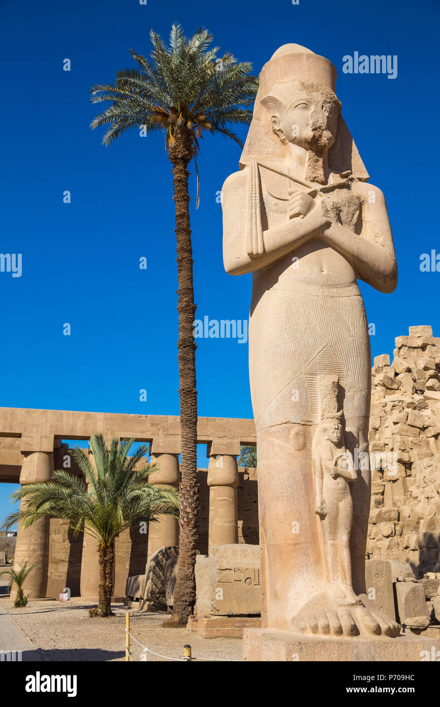 Egitto Luxor Tempio di Karnak, colossale statua di re Ramesse II con sua figlia piegate'anta Foto Stock