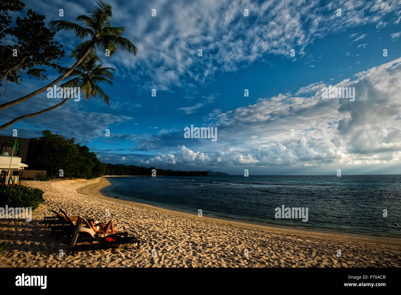 Immersione su una morbida luce del pomeriggio alle Seychelles, un turista è rilassante su una spiaggia dorata Foto Stock