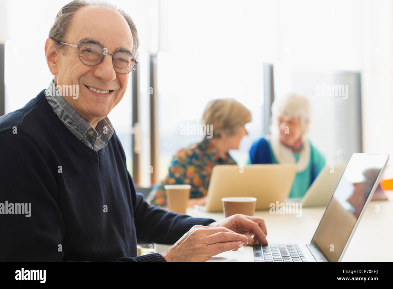 Ritratto sorridente e fiducioso imprenditore senior utilizzando laptop in sala conferenza incontro Foto Stock