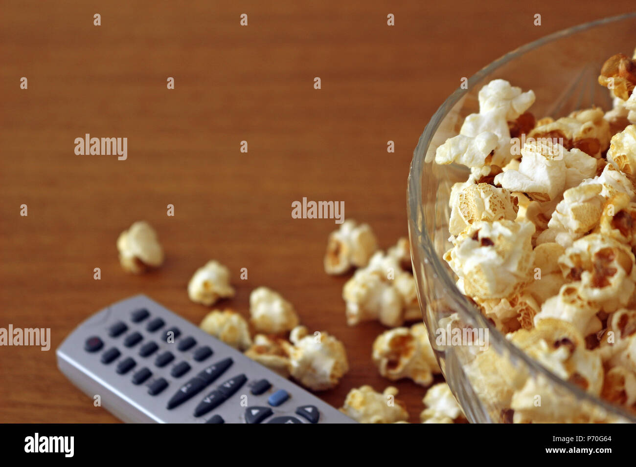 Il Popcorn in una ciotola accanto a un telecomando Foto Stock