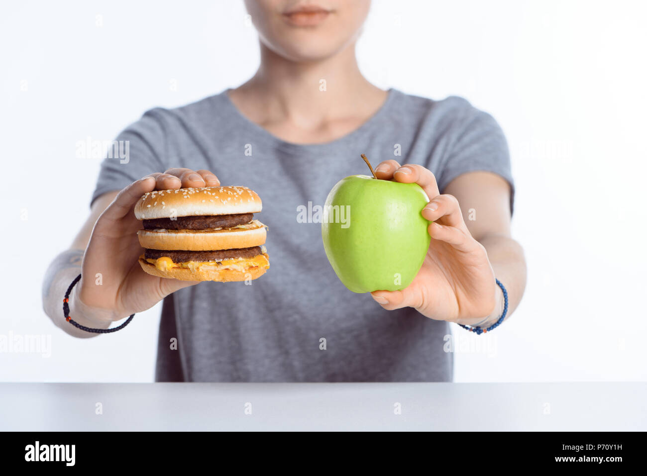 Vista ravvicinata della donna che mantiene fresche e mature e apple hamburger Foto Stock