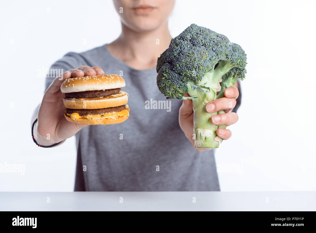 Vista ravvicinata della donna che mantiene freschi maturi i broccoli e hamburger Foto Stock