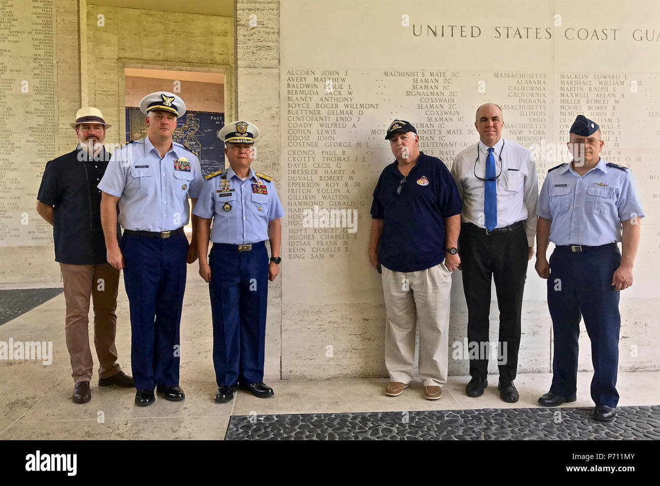 Officer responsabile Commodore Joel Garcia, Philippine Coast Guard, Lt. La Cmdr, Jeremy Obenchain ,U.S. Guardia costiera, consulente marittimo di difesa per la riduzione della minaccia e dell'agenzia U.S. Ambasciata, e Chief Petty Officer John O'Neil, U.S. Coast Guard veterani di guerra, di associazione e di altri ospiti di stand per una foto a livello militare Cimitero Americano, 9 maggio 2017. La cerimonia è stata culminata con il rivelare di Lt. Crotty il nome ormai inciso sull'U.S. La guardia costiera della parete nel cimitero. Foto Stock