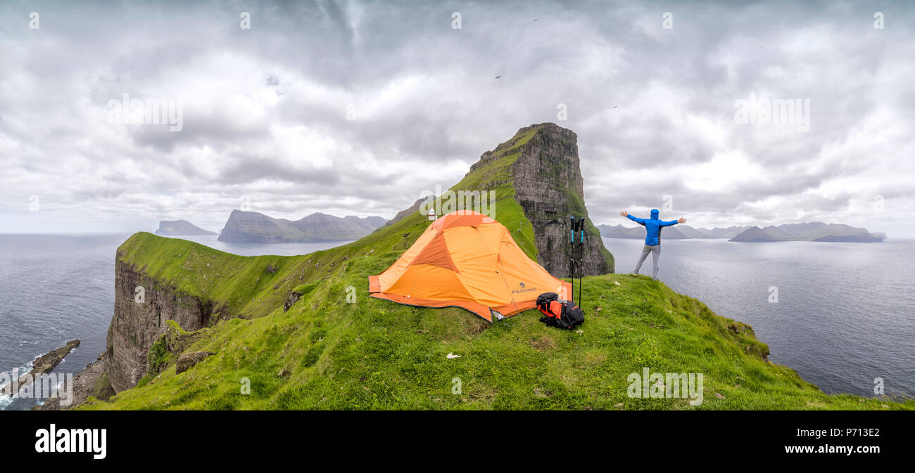 Panoramica di escursionista e tenda attorno Kallur faro, Kalsoy Isola, Isole Faerøer, Danimarca, Europa Foto Stock