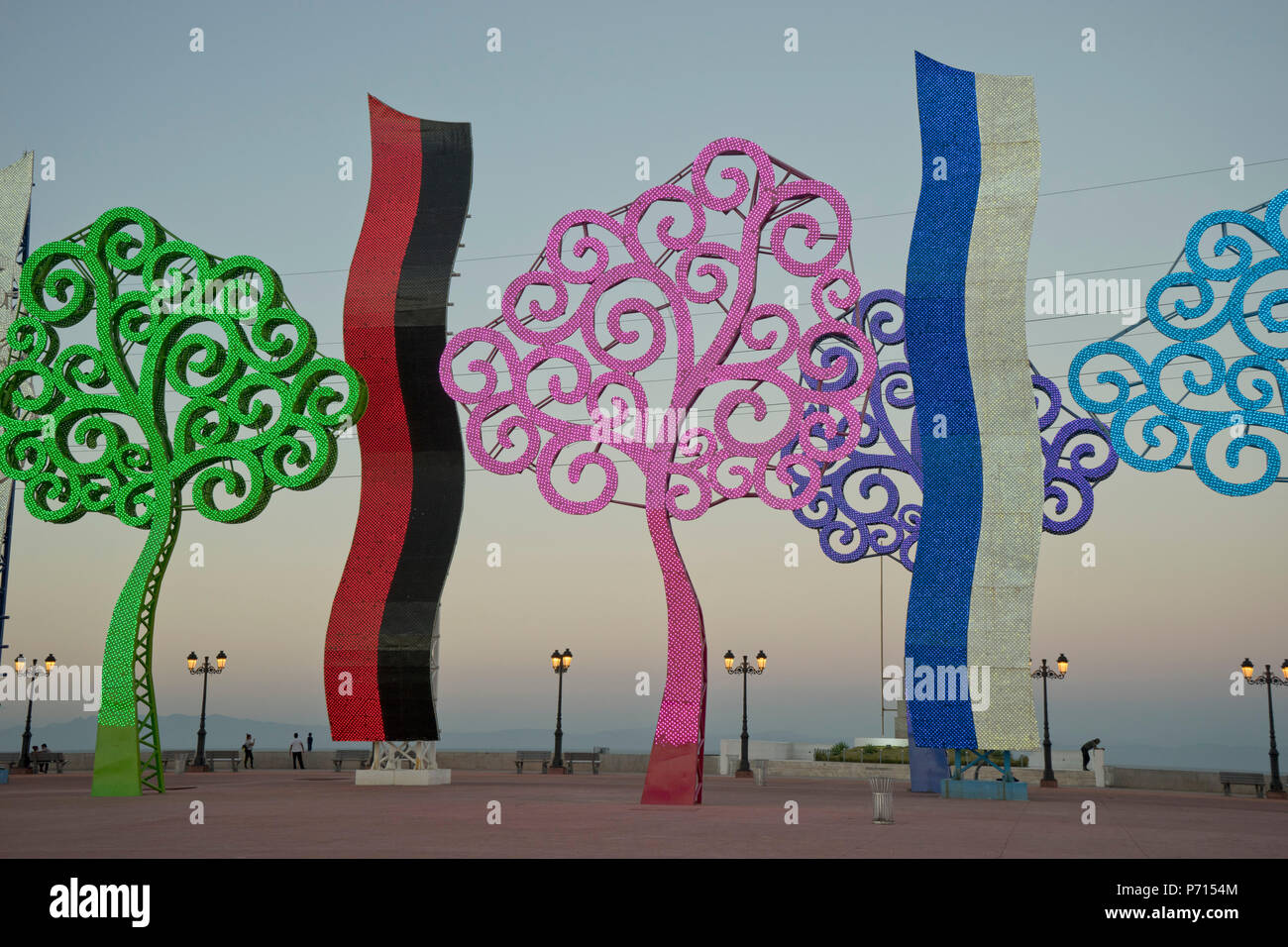 La gente di sera in riva al lago malecon, con alberi di metallo illuminata di notte, Managua, Nicaragua america centrale Foto Stock