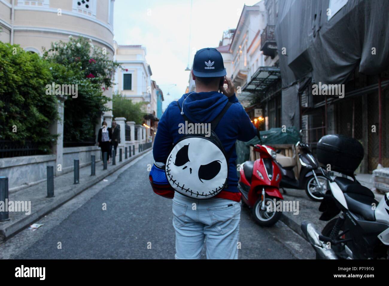 Uomo che indossa Jack Skellington bag in strada di Atene in Grecia Foto Stock