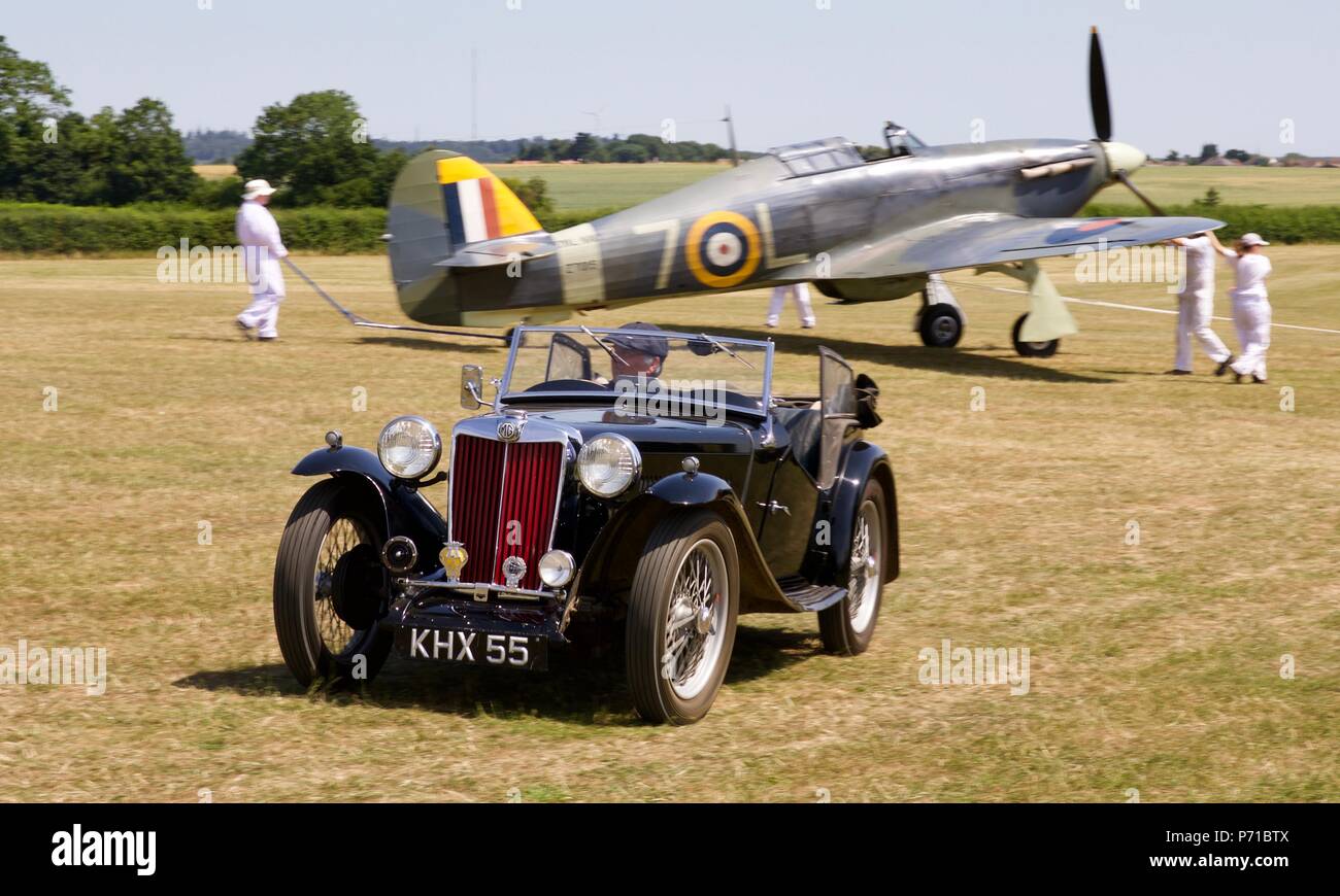 1939 MG Midget ta con un 1941 Mare Hawker Hurricane in background Foto Stock